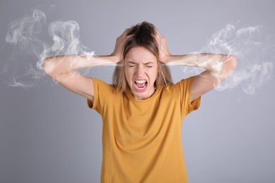 Image of Stressed and upset young woman on grey background