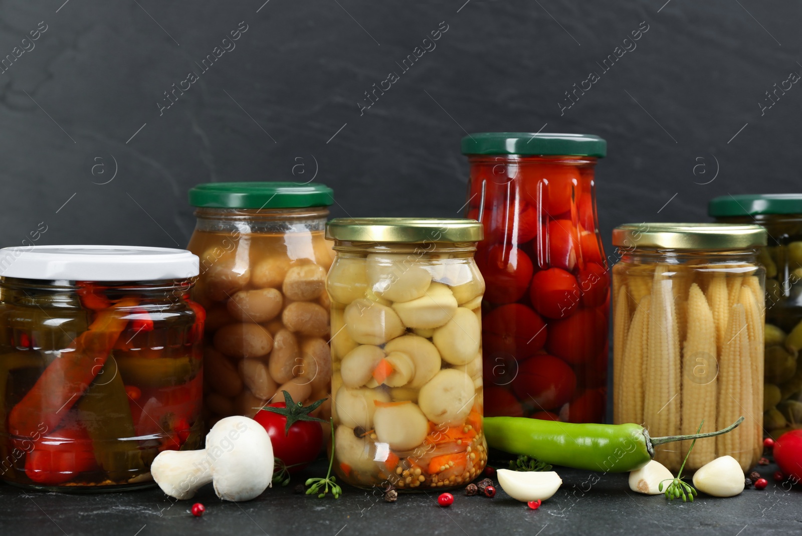 Photo of Jars of pickled vegetables on grey background