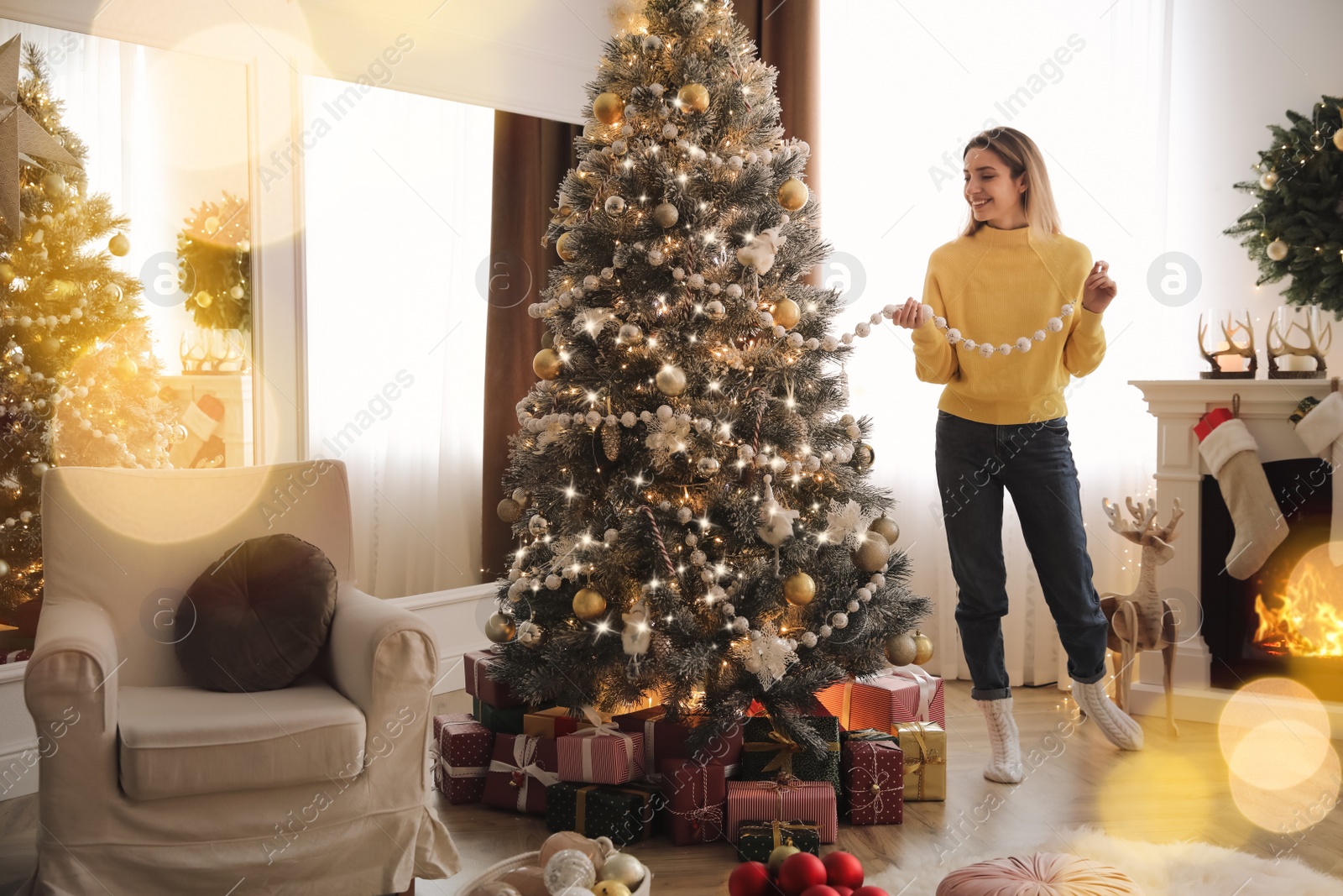 Photo of Beautiful woman decorating Christmas tree at home