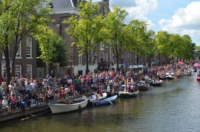 AMSTERDAM, NETHERLANDS - AUGUST 06, 2022: Many people in boats at LGBT pride parade on river