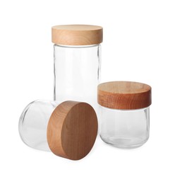 Photo of Three empty glass jars with wooden lids isolated on white