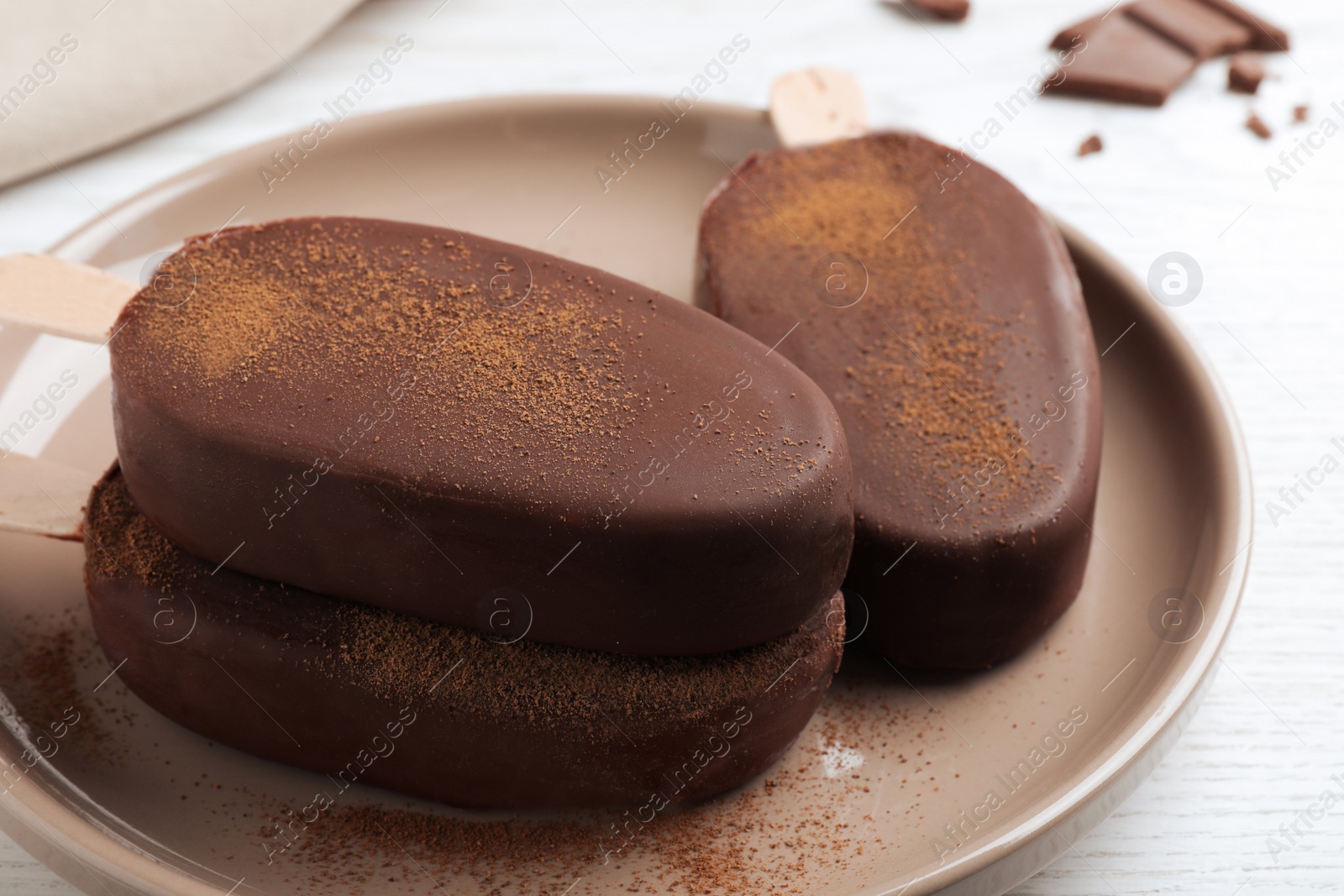 Photo of Delicious glazed ice cream bars on white wooden table, closeup