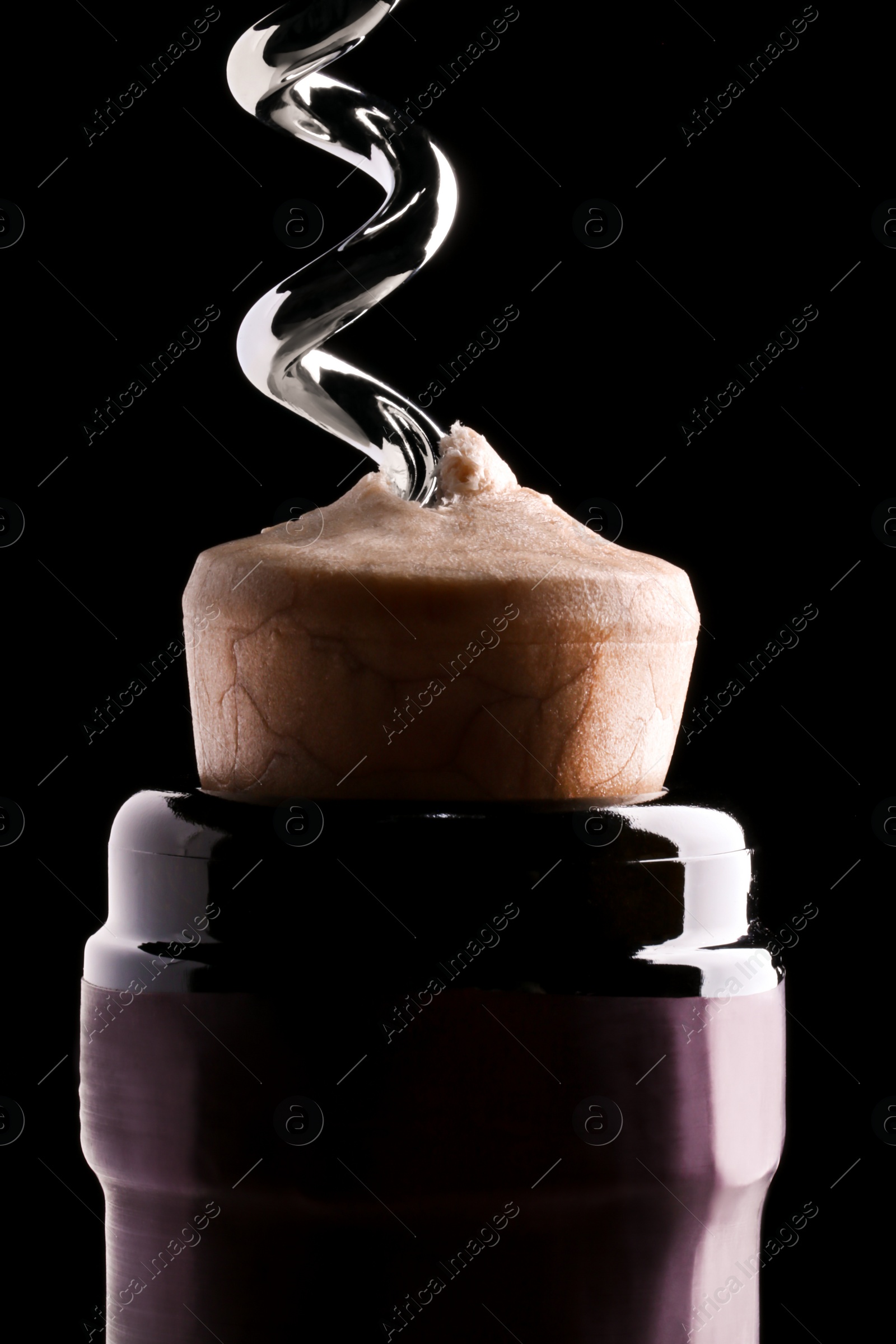 Photo of Opening wine bottle with corkscrew on dark background, closeup