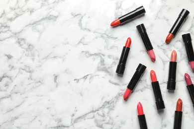 Photo of Different lipsticks and space for text on marble background, flat lay