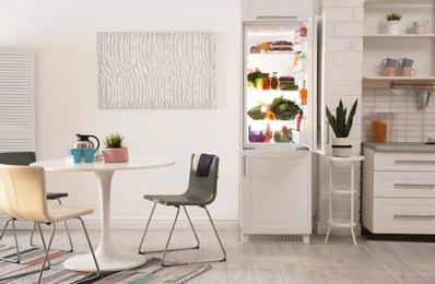 Photo of Stylish kitchen interior with refrigerator full of products