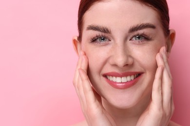 Portrait of smiling woman on pink background, closeup. Space for text