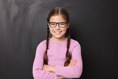 Photo of Back to school. Cute girl in glasses near chalkboard