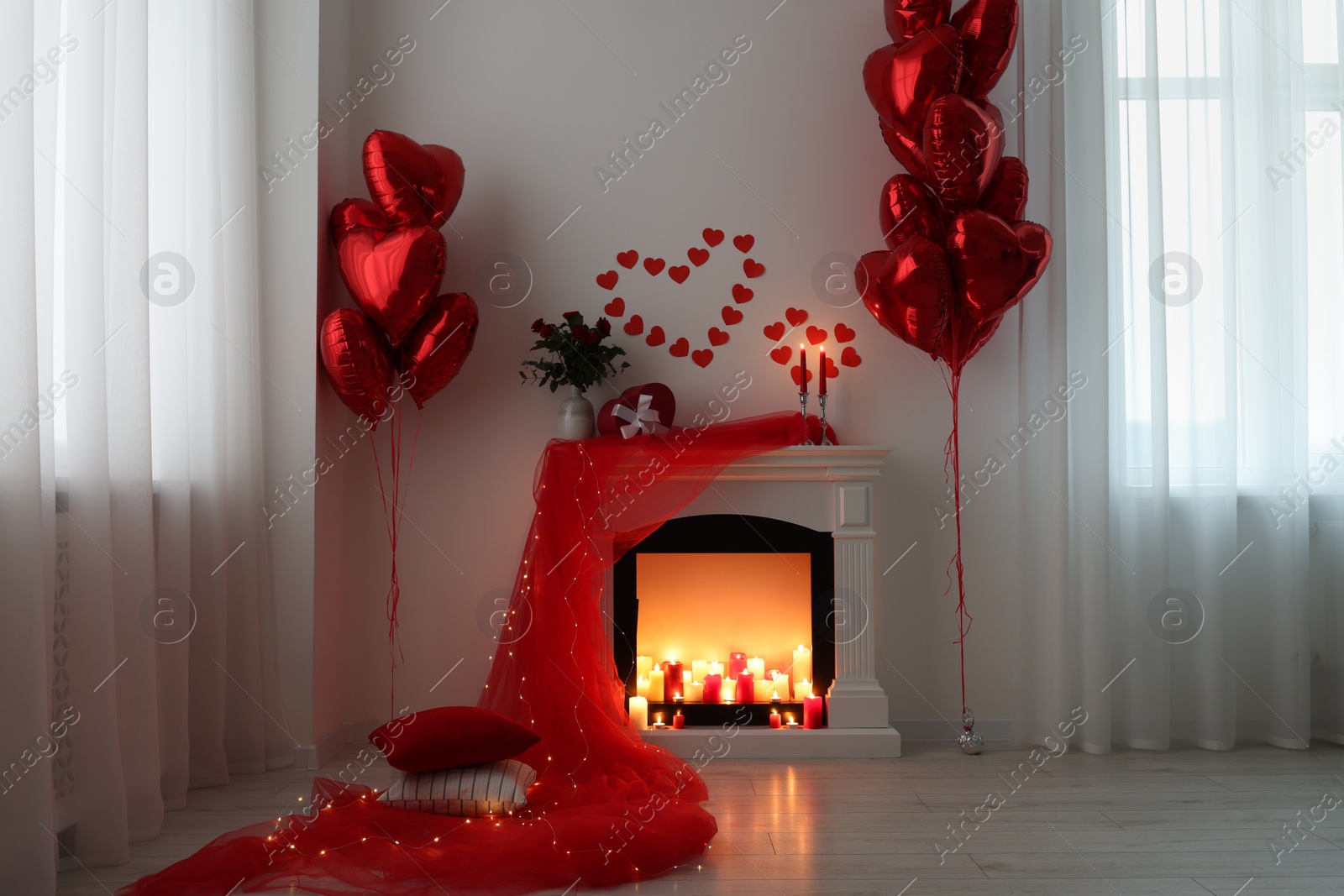 Photo of Stylish room with fireplace and Valentine's day decor. Interior design