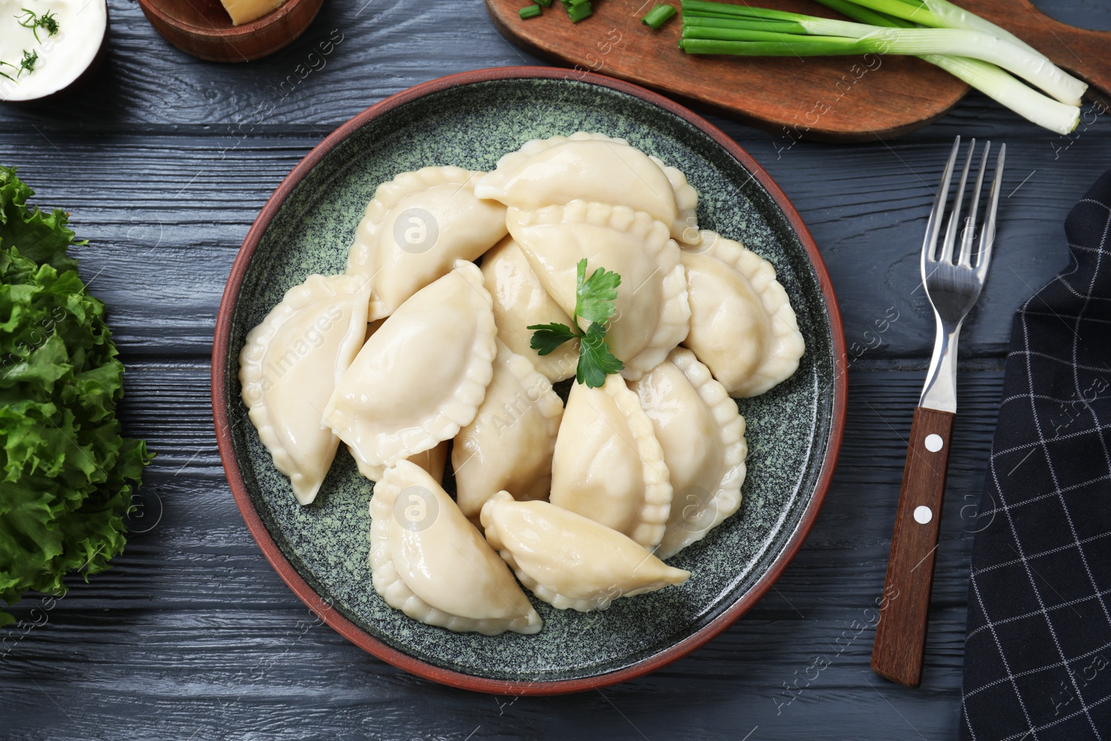 Photo of Flat lay composition with tasty dumplings served on wooden table