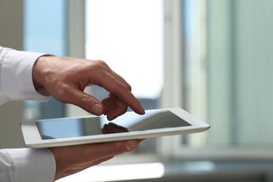 Closeup view of man using new tablet indoors