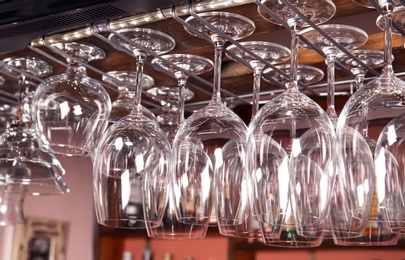 Photo of Clean glasses hanging over counter in bar