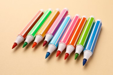 Many bright colorful markers on beige background