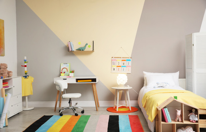 Photo of Stylish child room interior with comfortable bed and desk