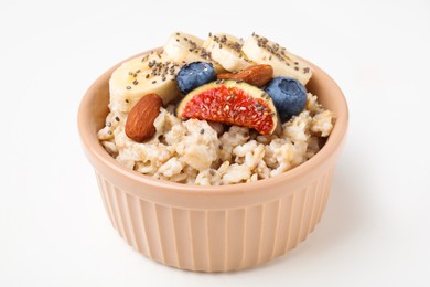 Photo of Bowl of oatmeal with blueberries, almonds, banana and fig pieces isolated on white