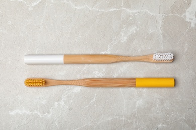 Bamboo toothbrushes on grey background, top view