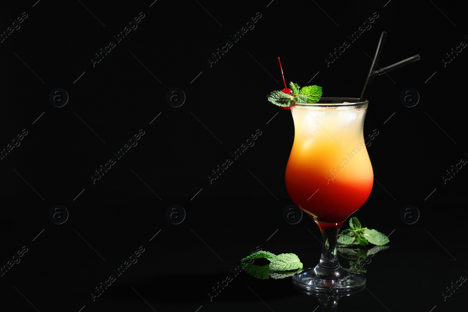 Photo of Just made appetizing cocktail Sex on the Beach, black background. Space for text