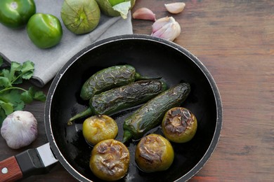 Photo of Different ingredients for cooking tasty salsa sauce on wooden table, above view