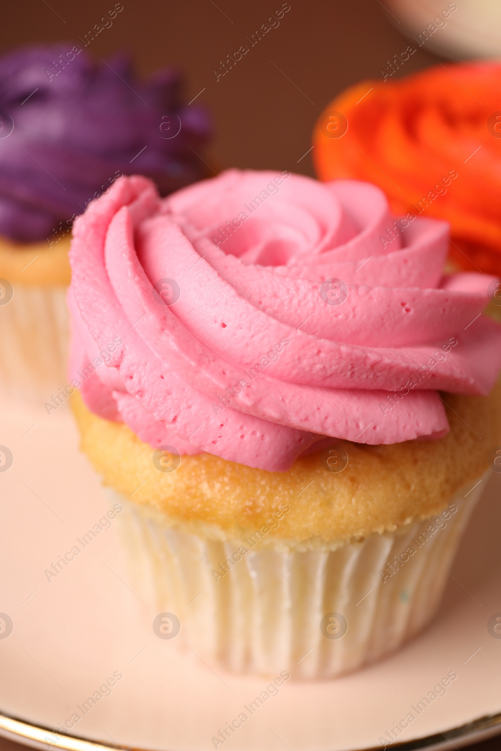 Photo of Delicious cupcakes with bright cream on plate, closeup