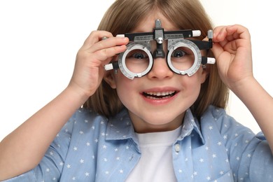 Photo of Vision testing. Little girl with trial frame on white background