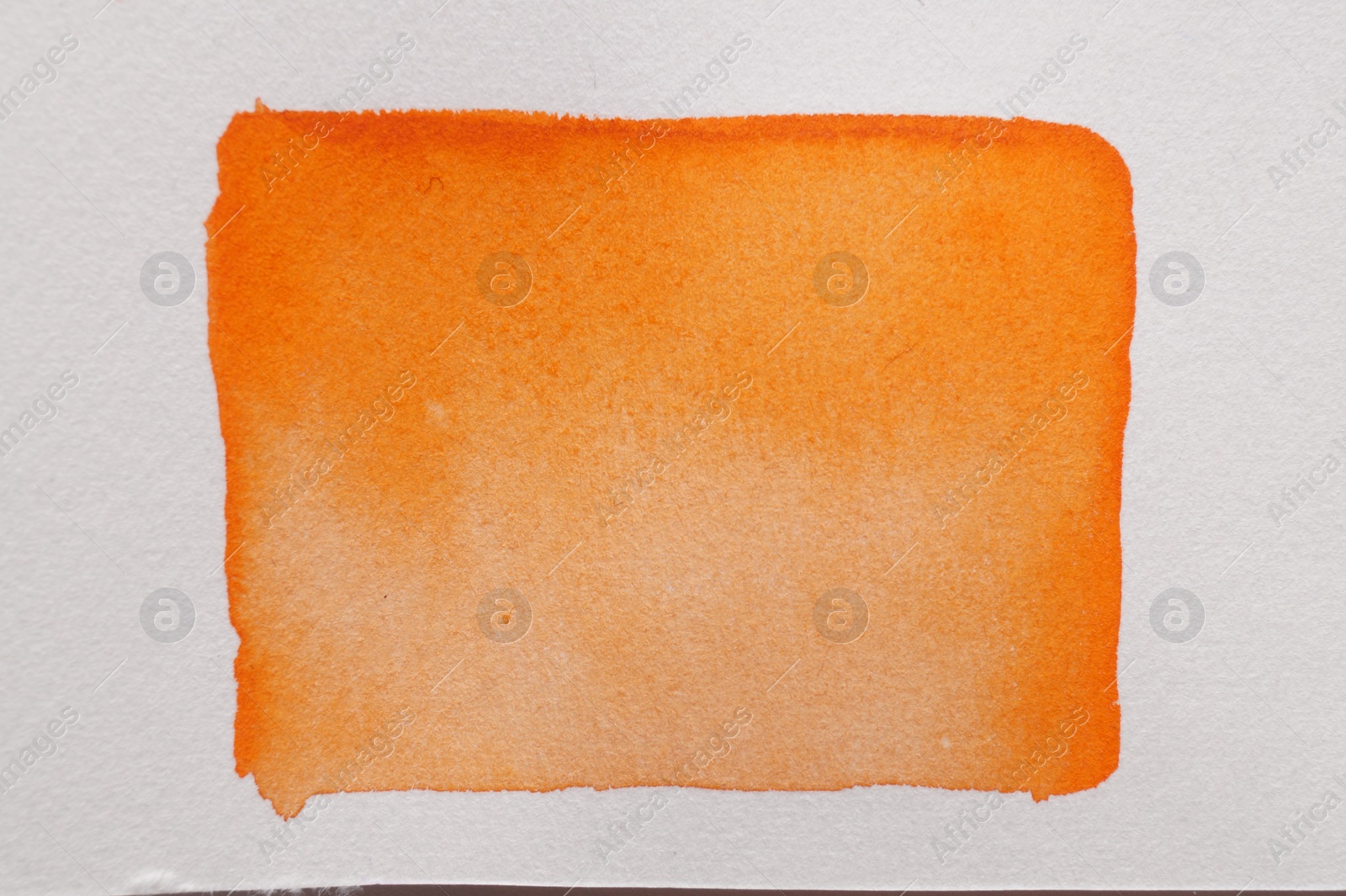 Photo of Orange watercolor rectangle on white canvas, top view