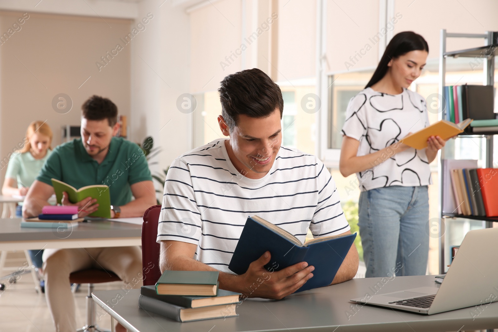 Photo of Students reading books and studying in library