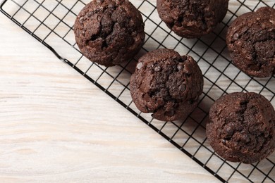 Delicious chocolate muffins on light wooden table, top view. Space for text