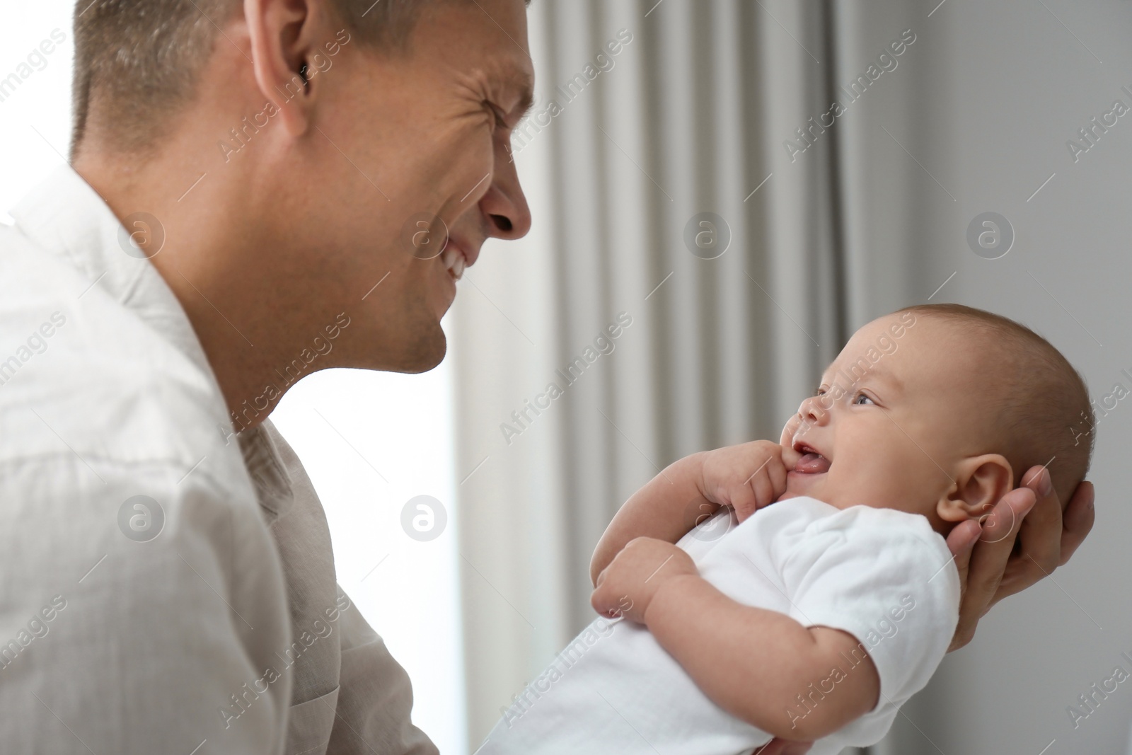 Photo of Happy father holding his cute baby at home