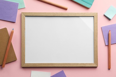 Photo of Blank white board with stationery on light pink background, flat lay. Space for text