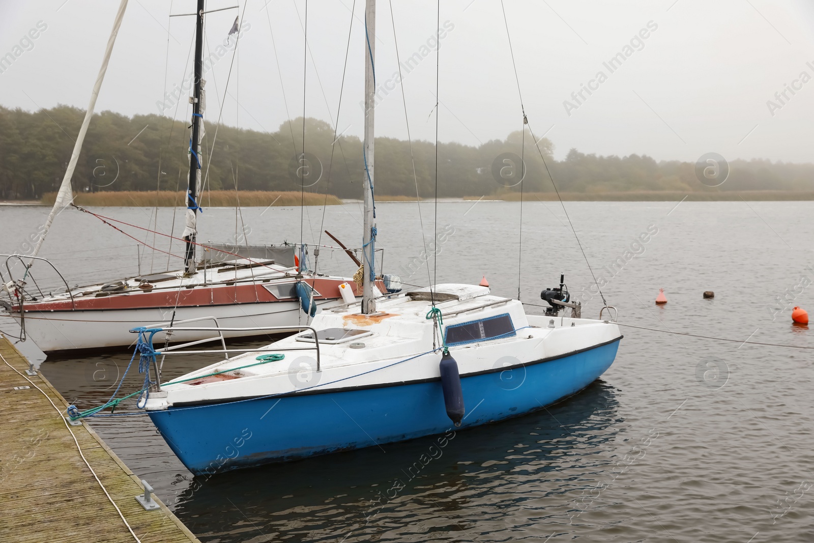 Photo of Picturesque view of wooden pier with moored boats