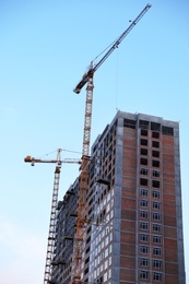 Construction crane and unfinished building against blue sky