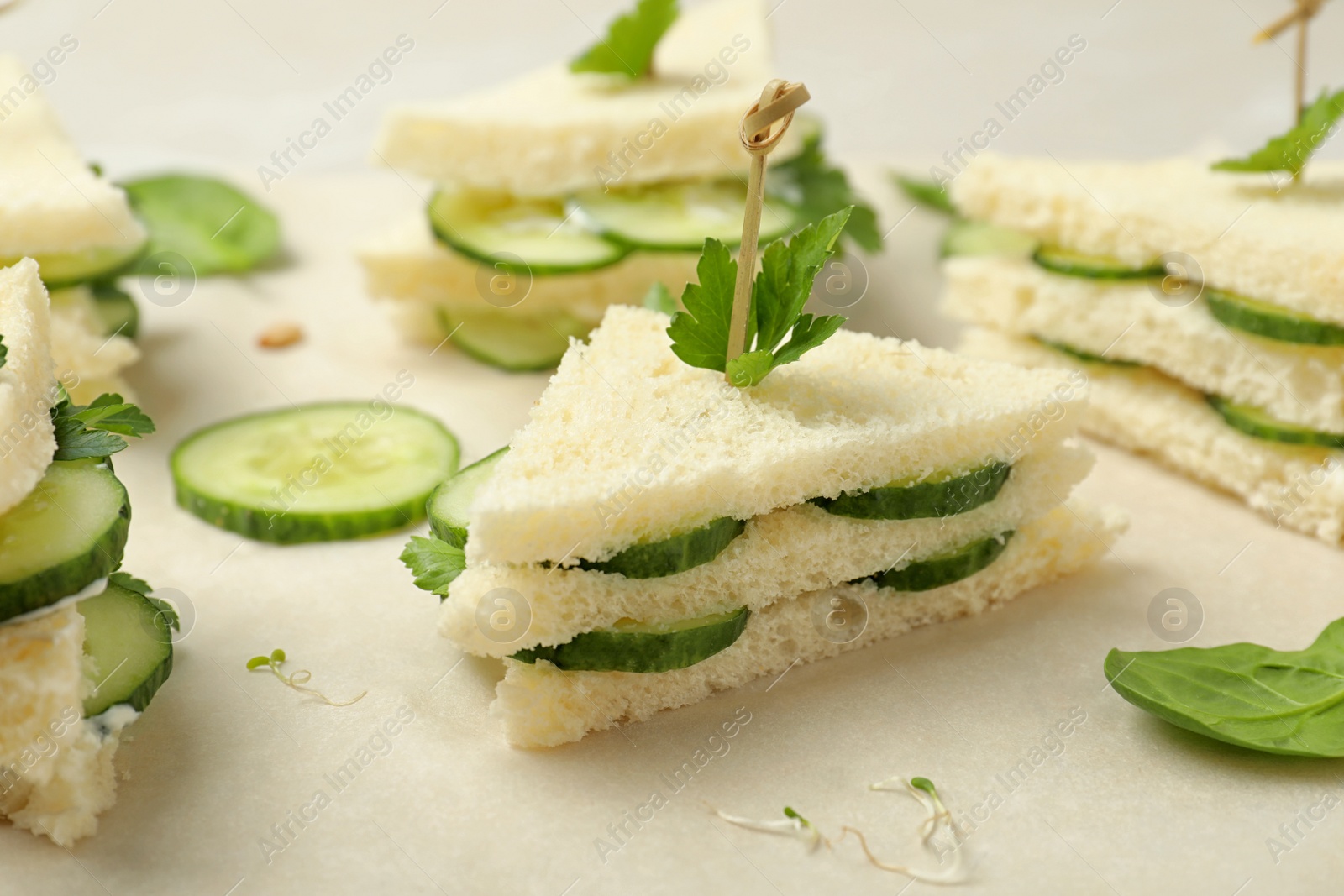 Photo of Traditional English cucumber sandwiches on parchment, closeup