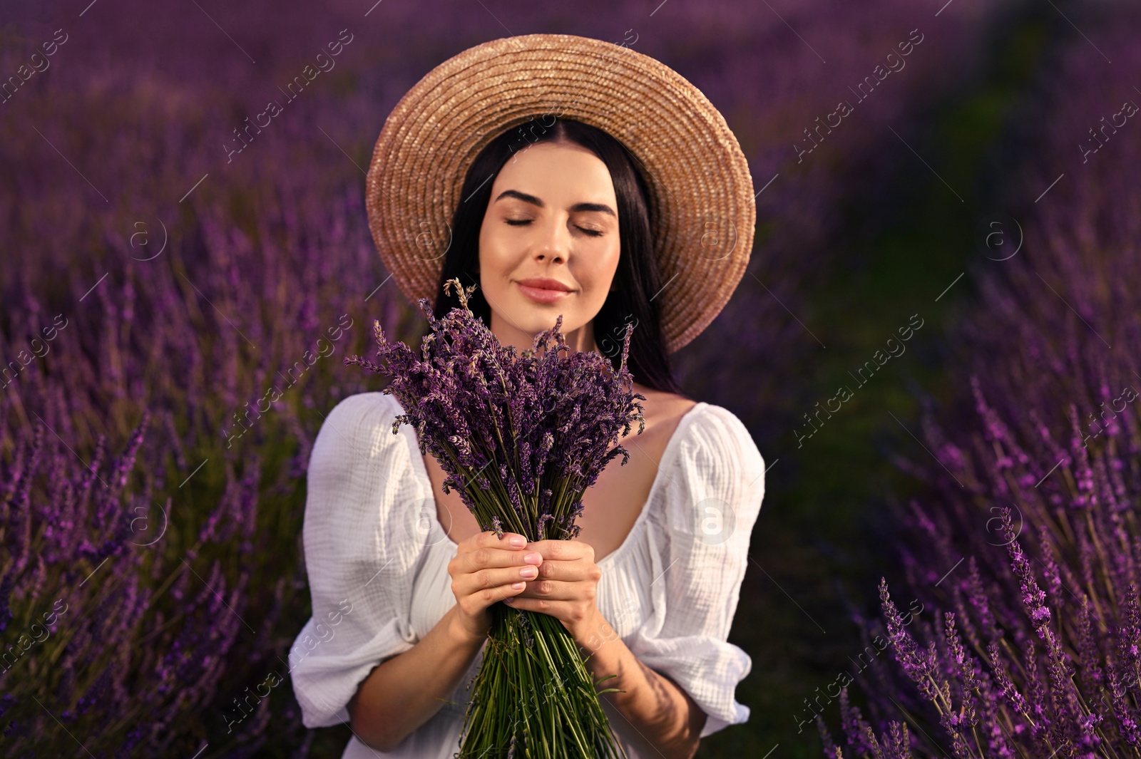 Photo of Beautiful young woman with bouquet in lavender field