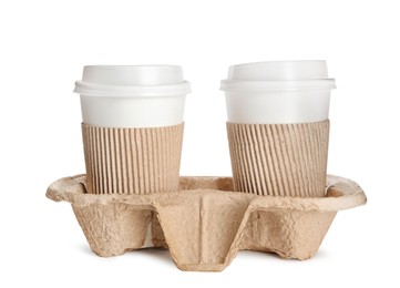 Photo of Takeaway paper coffee cups with sleeves in cardboard holder on white background