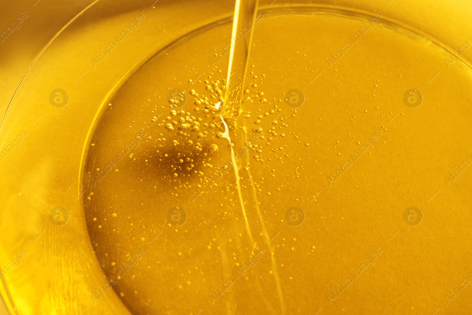 Photo of Pouring cooking oil into bowl, closeup view