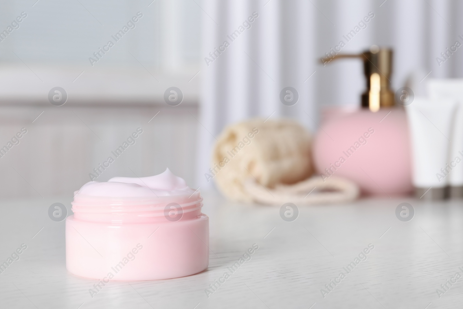 Photo of Jar of body care product on table against blurred background. Space for text