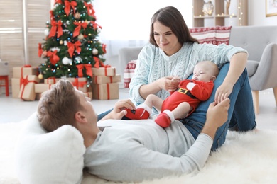 Happy couple with baby celebrating Christmas together at home