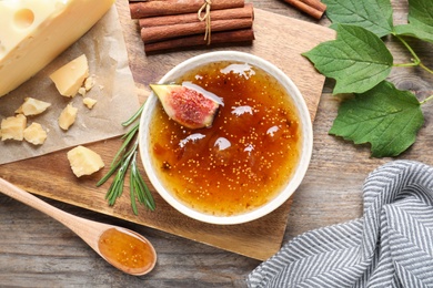 Photo of Flat lay composition with delicious fig jam on wooden table