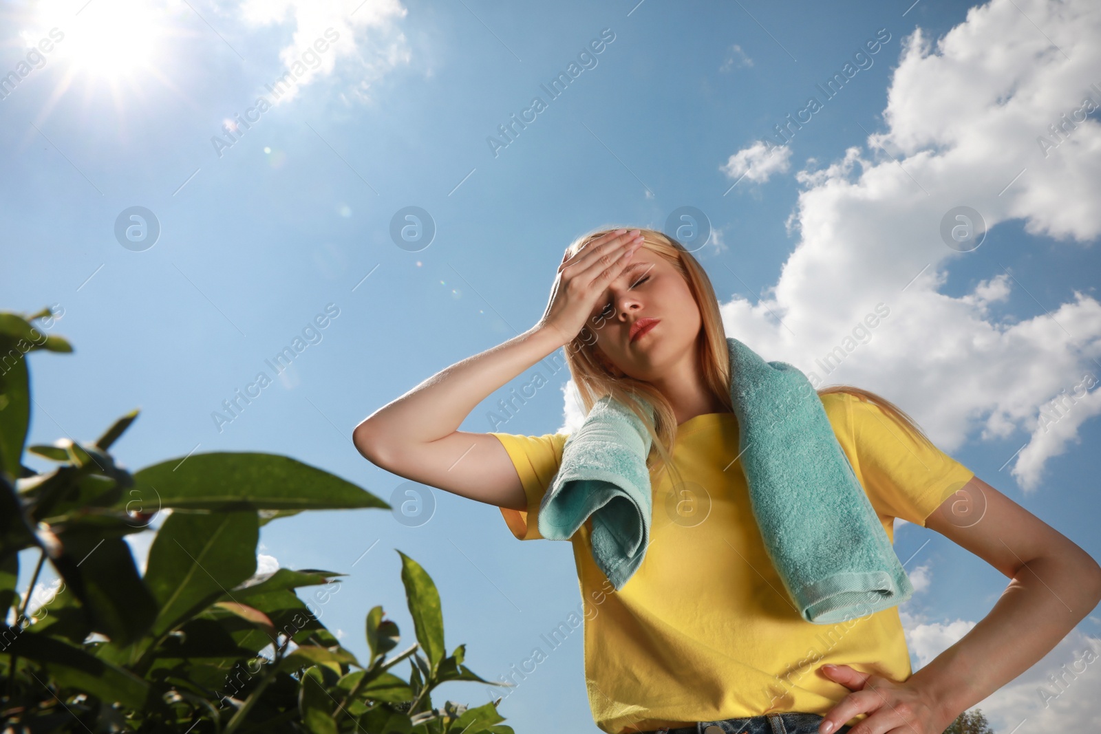 Photo of Woman with towel suffering from heat stroke outdoors