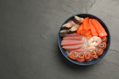 Photo of Delicious mackerel, salmon, shrimps and tuna served with funchosa on grey table, top view with space for text. Tasty sashimi dish