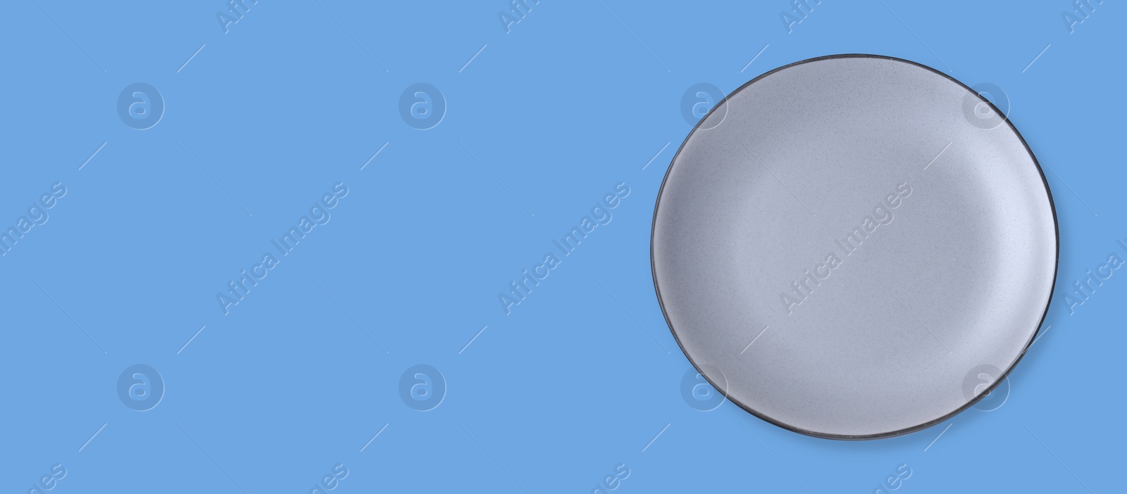 Image of Empty light gray ceramic plate on light blue background, top view and space for text. Banner design