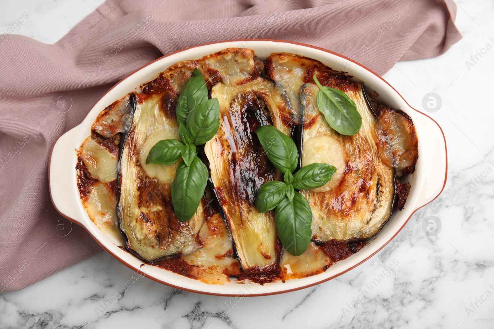 Photo of Delicious eggplant lasagna in baking dish on white marble table, top view