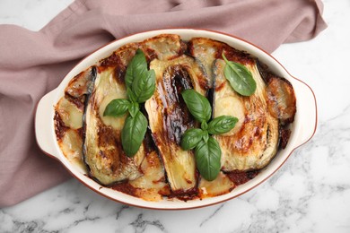 Photo of Delicious eggplant lasagna in baking dish on white marble table, top view