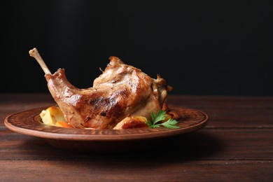 Photo of Tasty cooked rabbit meat with potatoes on wooden table, closeup. Space for text