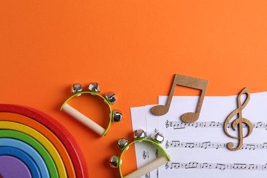 Tools for creating baby songs. Flat lay composition with tambourines for kids on orange background. Space for text