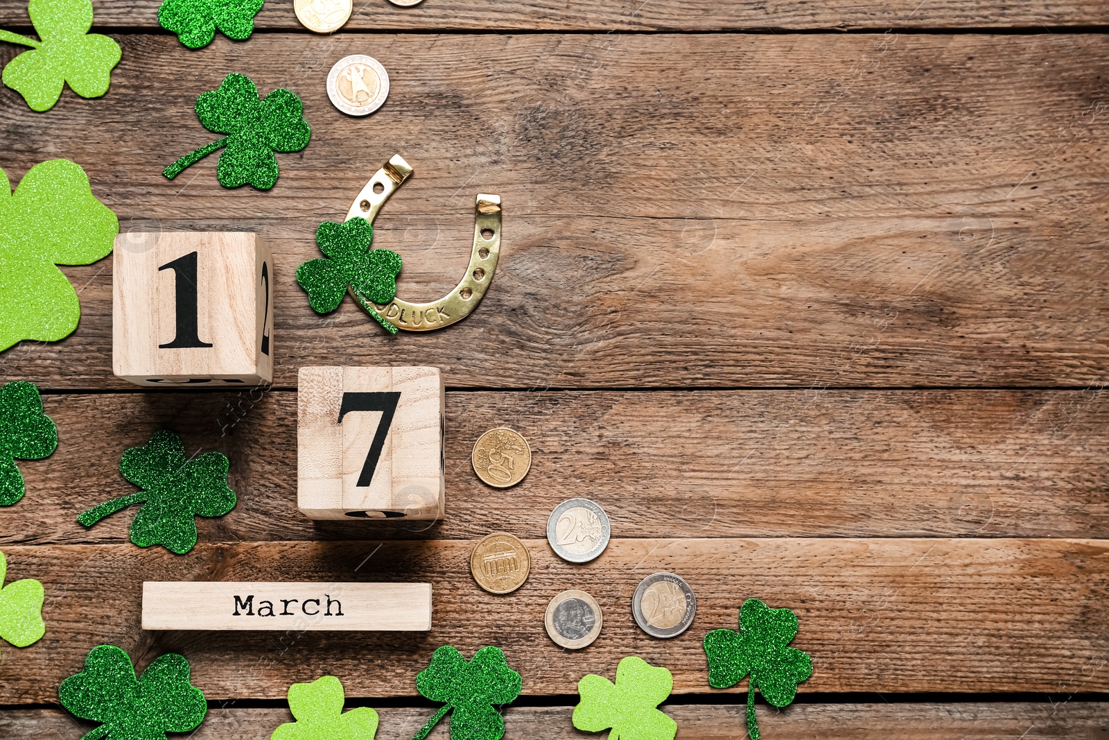 Photo of Flat lay composition with block calendar on wooden table, space for text. Saint Patrick's Day celebration