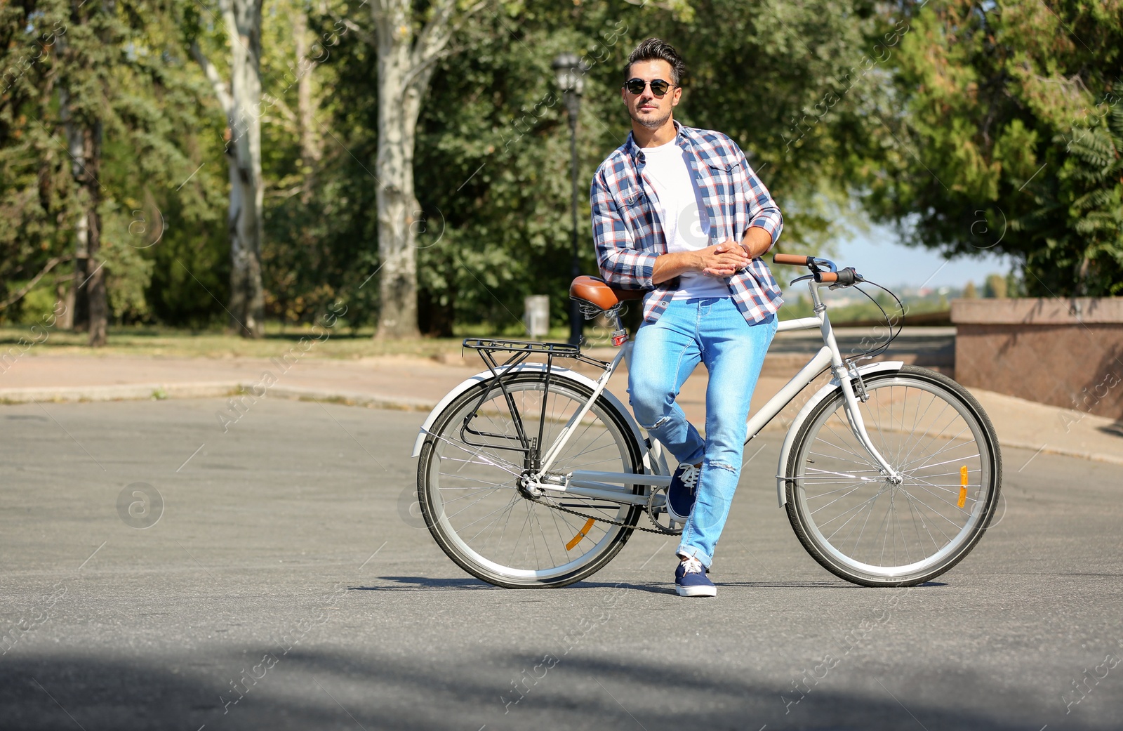 Photo of Handsome young hipster man with bicycle outdoors