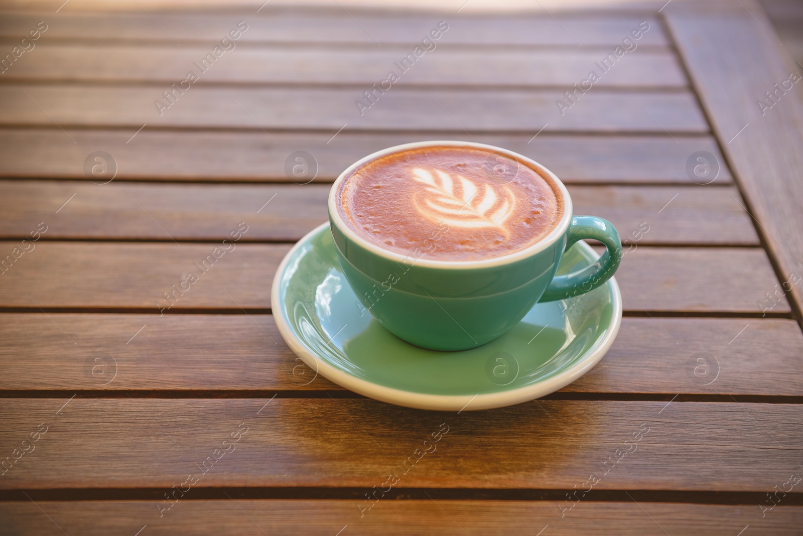 Photo of Cup of aromatic hot coffee on wooden table, space for text