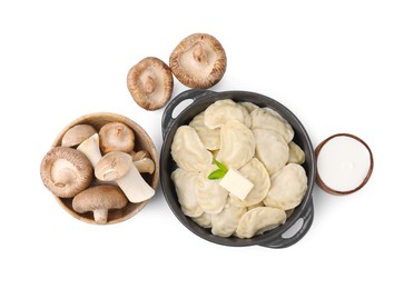 Serving pan with delicious dumplings (varenyky), fresh mushrooms and sour cream isolated on white, top view