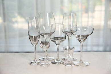 Photo of Different elegant empty glasses on grey table indoors