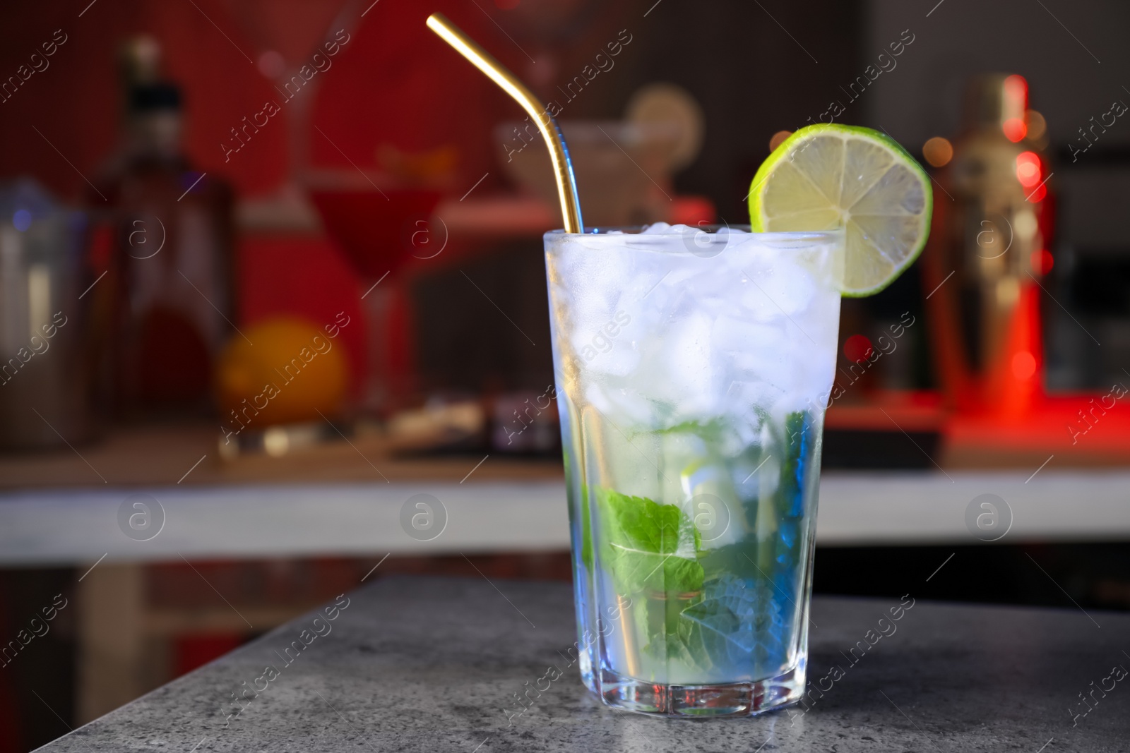 Photo of Mojito cocktail on grey table in bar. Space for text